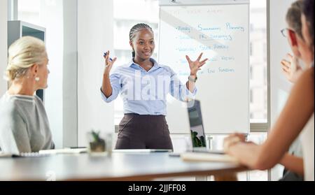 Allons-y et avons une semaine réussie. Une jeune femme d'affaires donne une présentation à ses collègues dans un bureau. Banque D'Images