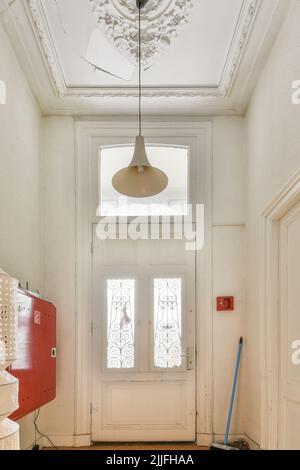 Intérieur moderne plat de style minimaliste avec couloir vide étroit éclairé par des lampes Banque D'Images