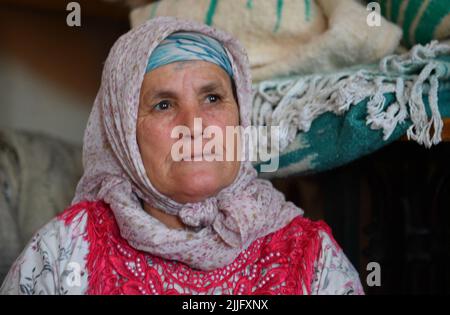 Les tisserands des vallées de l'ait Boulli et de l'ait Bougmez font les tapis de l'azilal. Les tapis azilal marocains sont un type de tapis berbère de la capitale provinciale du Maroc central dans les montagnes du Haut Atlas à environ 180 km de Marrakech. Ils sont faits de pure laine de mouton mélangée avec du coton et tissés horizontalement à l'aide d'une ligne quadrillée de nœuds. Les tapis du Maroc sont de haute qualité les rendant très durables, c'est pourquoi ils sont souvent trouvés dans les écoles, les bureaux, les maisons, et les zones de trafic élevé dans le monde entier. Ils résistent aux taches et sont généralement plus abordables que les tapis en peluche. Banque D'Images