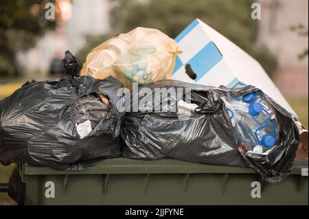 Poubelles débordant pleines de déchets et de déchets dans la rue. Banque D'Images