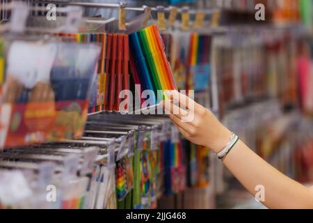 vue courte d'une femme en bracelets perlés choix d'un lot de stylos feutres colorés dans un magasin de papeterie Banque D'Images