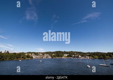 Ciel bleu soleil brillant Bowness Bay sur le lac Windermere le parc national site du patrimoine mondial Cumbria Nord-Ouest Angleterre Royaume-Uni Grande-Bretagne Banque D'Images