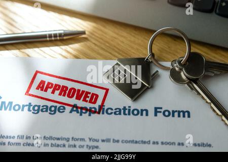 approbation du formulaire de demande de prêt hypothécaire et des clés de maison neuves sur la table du bureau de banque Banque D'Images