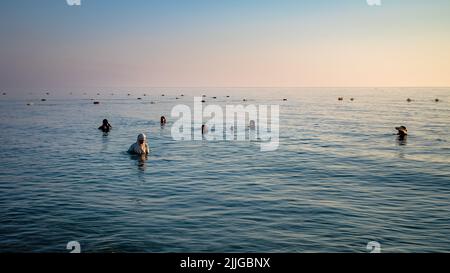 Les femmes se baignent dans la mer Méditerranée à l'aube près de Port El Kantaoui, en Tunisie. Banque D'Images