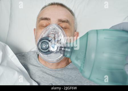 D'après la prise ci-dessus d'un personnel médical méconnaissable qui effectue une RCP pour un patient mature en salle d'urgence Banque D'Images