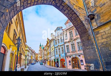 Les maisons de ville colorées, les boutiques de touristes et les cafés sur la rue Mostecka, vu à travers l'arche du pont Mala Strana Tour du pont Charles, Prague, Tchèque Banque D'Images