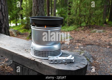 Hameenlinna, Finlande. 10 juillet 2022. Trangia, le poêle de camping portatif sur un banc dans une forêt Banque D'Images