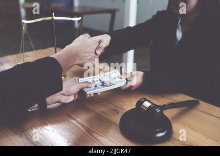 Le partenaire donne de l'argent de pot-de-vin en enveloppe à un autre homme d'affaires. Les concepts de corruption et de lutte contre la corruption. Banque D'Images