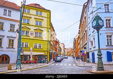 Le paysage urbain d'époque avec des maisons historiques colorées, de petits restaurants, des pubs et une vieille horloge en premier plan, rue Trziste, Prague, République tchèque Banque D'Images