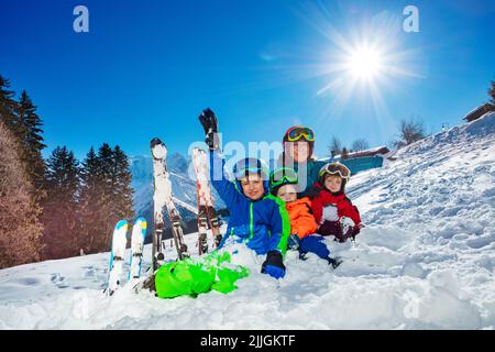 Enfants et mère - les vacances de ski en famille s'assoient ensemble dans la neige Banque D'Images