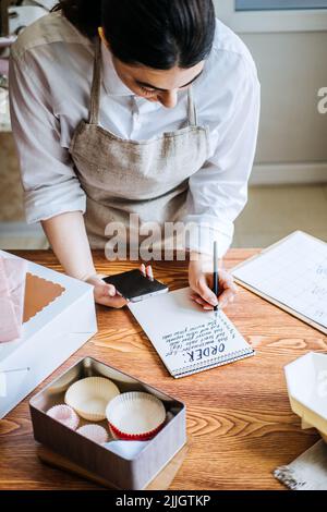 Propriétaire d'une petite entreprise locale de confiserie, de sucrerie, de pâtisserie. Femme asiatique arabe pâtisserie chef Banque D'Images