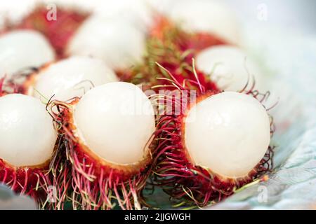 L'écorce de rambutan est coupée en deux sur un plat en verre et prête à manger. Banque D'Images