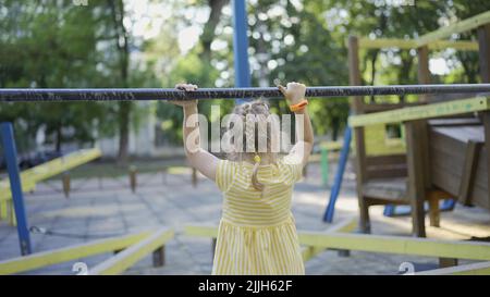 Odessa, Ukraine, Europe de l'est. 26th juillet 2022. Une petite fille mignonne joue sur le terrain de jeu. Enfant fille jouant sur l'aire de jeux dans le parc de la ville (Credit image: © Andrey Nekrasov/ZUMA Press Wire) Banque D'Images