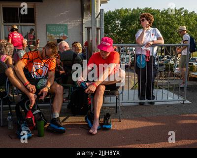 Deux marcheurs massent leurs pieds lors du plus grand événement de randonnée de plusieurs jours au monde. La marche des quatre jours (en néerlandais 'Vierdaagse') est considérée comme le premier exemple de l'esprit sportif et des liens internationaux entre militaires et civils de nombreux pays différents. Après deux ans d'annulation, il a été retenu à nouveau, mais le premier jour a été annulé en raison de températures chaudes, transformant les quatre marches en trois jours de marche. Il s'agit de l'édition 104 et le total officiel des marcheurs enregistrés était de 38 455 dans 69 pays. Ils peuvent choisir de marcher 30km, 40km ou 50km par jour. Banque D'Images