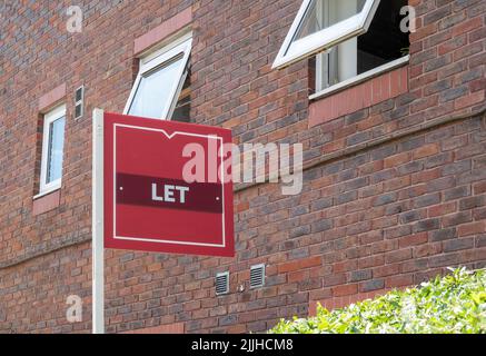 Un agent immobilier laisse signer à l'extérieur d'un bloc d'appartements où les propriétés sont à louer Banque D'Images