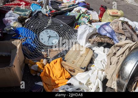 Haifa, Israël - 20 juillet 2022, scène du marché aux puces, avec des vendeurs et des acheteurs, dans le centre-ville de Haïfa, en Israël. Une horloge ronde repose sur une pile de vêtements Banque D'Images