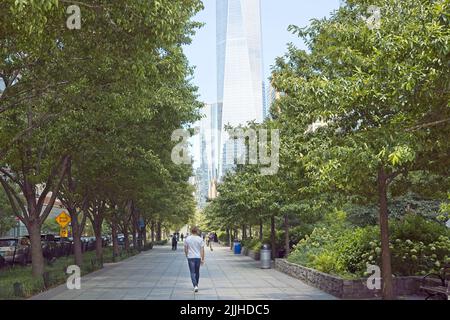 New York, NY, Etats-Unis - 25 juillet 2022 : personnes marchant le long du sentier piétonnier de la voie verte de l'Hudson dans le bas de Manhattan avec le World Trade Center illustré Banque D'Images