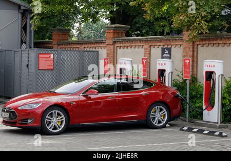 Poznan, Pologne. 26 juillet 2022 : les voitures Tesla rouges se chargent à une station de Supercharger Tesla. Les stations de surcompresseur permettent de charger rapidement les voitures en ligne Banque D'Images