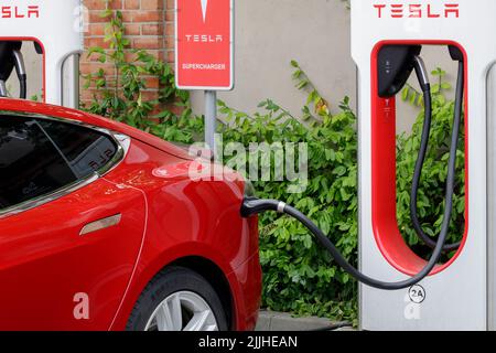 Poznan, Pologne. 26 juillet 2022 : gros plan d'une voiture électrique Tesla en charge. Station de charge de voiture Tesla. Banque D'Images