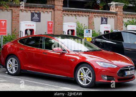 Poznan, Pologne. 26 juillet 2022 : un Tesla rouge lors de la charge à la station de Supercharger. Le compresseur Supercharger permet une charge rapide pour les véhicules électriques. Banque D'Images