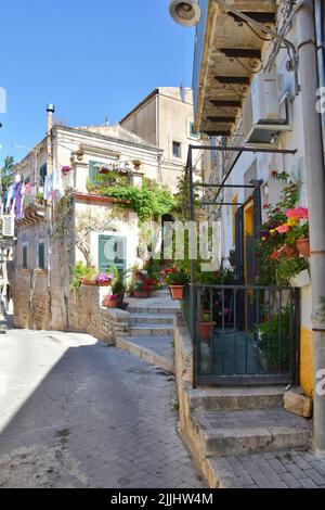 Une rue étroite avec de vieilles maisons et des plantes le jour ensoleillé de Modica, ville sicilienne en Italie Banque D'Images