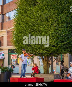 Musicien jouant du violon. Le garçon jouant du violon debout dans une ruelle sur une rue de ville. Portrait de petit musicien avec instrument. Voyage photo-19 juillet, Banque D'Images