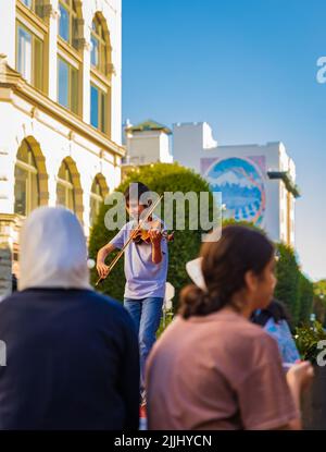 Musicien jouant du violon. Le garçon jouant du violon debout dans une ruelle sur une rue de ville. Portrait de petit musicien avec instrument. Voyage photo-19 juillet, Banque D'Images