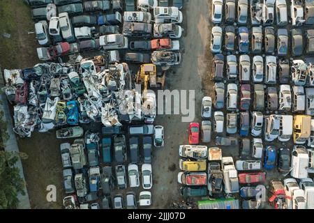 Vue aérienne du grand parking de junkyard avec des rangées de voitures brisées jetées. Recyclage des vieux véhicules Banque D'Images