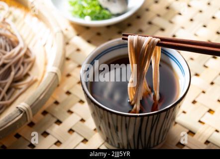 Zaru-soba et condiments sur une table en bois. Les nouilles soba sont immergées dans la soupe de nouilles. Zaru soba est une cuisine japonaise traditionnelle. Banque D'Images