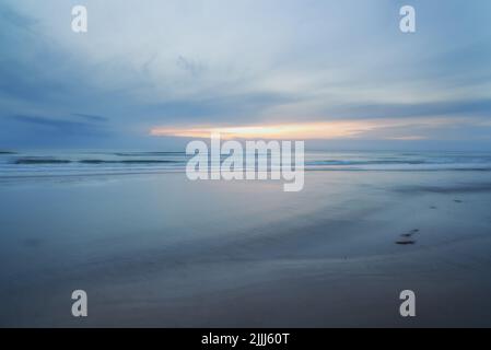 Une vue magnifique, calme et tranquille de la plage et le coucher du soleil ciel sur l'horizon avec espace copie. Un paysage paisible et pittoresque d'eau de sable sans fin Banque D'Images