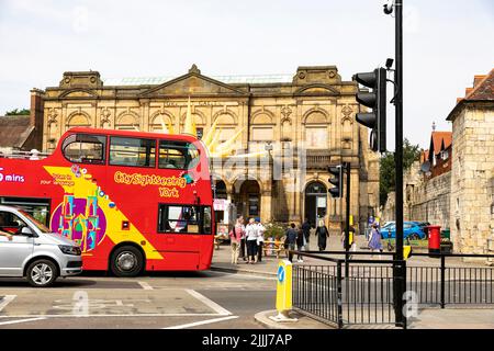 Centre-ville de York, Angleterre, bus touristique à impériale rouge offrant des visites pour les visiteurs de la ville, passe devant la York Art Gallery, Angleterre, Royaume-Uni Banque D'Images