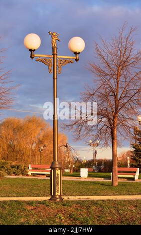 Strelka Park sur la rive de la rivière. Une lampe de rue avec les armoiries de la ville à l'aube. Yaroslavl, Russie, 2022 Banque D'Images