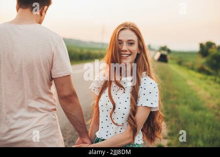Photo d'un couple heureux marchant sur une route de campagne. Un mode de vie sain. Amour, rencontres. Banque D'Images