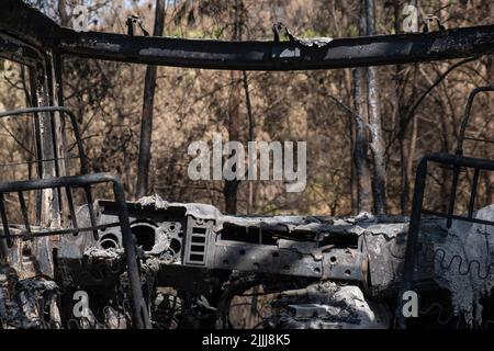 Une voiture est brûlée dans l'urbanisation River Park, Pont Vilomara, Barcelone. Traces de feu sur la végétation et les éléments urbains après le feu sur 17 juillet qui a dévasté 1 500 hectares laissant quelques maisons brûlées à Pont de Vilomara (Barcelone) aux portes de Sant Llorenç del Munt i l, parc naturel d'Obac. Banque D'Images