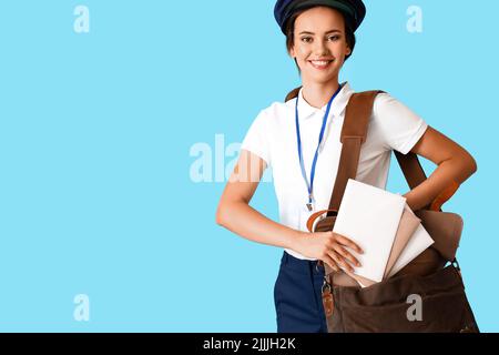 Jeune femme de poste avec lettres et sac sur fond bleu Banque D'Images