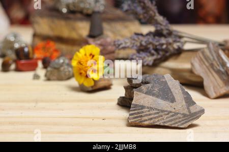 Morceaux de poterie amérindienne antique avec cristaux et fleurs sur autel de méditation Banque D'Images