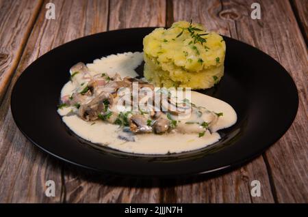 Recette pour le filet de dorade dans une sauce au vin blanc avec purée de pommes de terre et champignons Banque D'Images