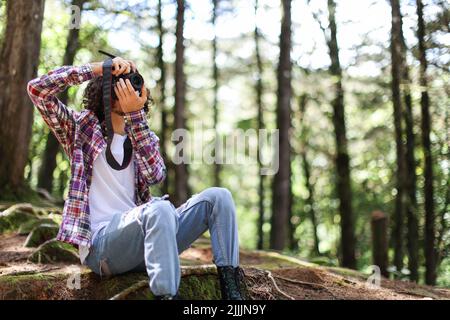 Photographe sans visage prenant des photos en regardant directement dans la forêt tenant un appareil photo au Costa Rica Banque D'Images