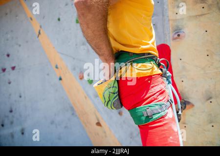 Rock homme grimpeur a poussé ses mains dans un sac de poudre de magnésie derrière son dos. Gros plan. Banque D'Images