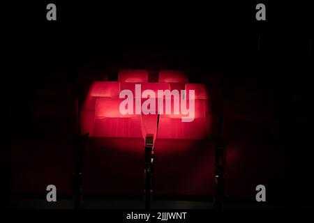 Sièges de théâtre rouge Emply avec cercle de spot. Banque D'Images