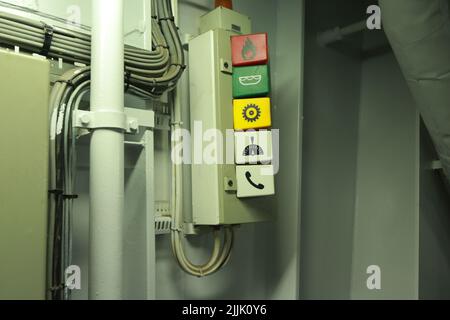 Intérieur de la salle des moteurs des bateaux de croisière avec portes étanches moteurs électriques et diesel, tuyaux d'eau, instruments de mesure, panneaux d'avertissement Banque D'Images