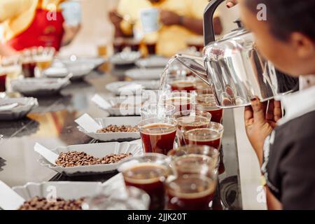 Femme versant de l'eau de la bouilloire pour déguster du café Banque D'Images