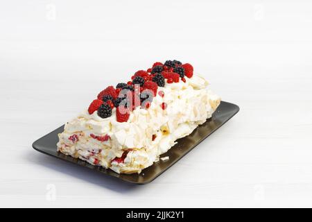 Délicieux dessert meringue maison avec baies sur table en bois blanc. Banque D'Images