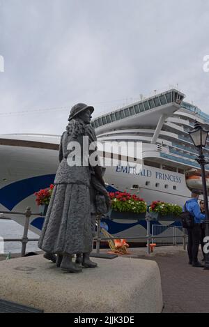 Les Psssengers du navire de croisière Emerald Princess regardent le monument Annie Moore sur le quai de Cobh, comté de Cork, Irlande, juillet 2022 Banque D'Images