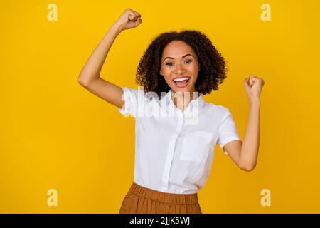 hoto de charmante fille positive soulève le bras vers le haut heureux voir la vente de rabais profiter du shout triomphe oui isolé sur fond jaune de couleur Banque D'Images