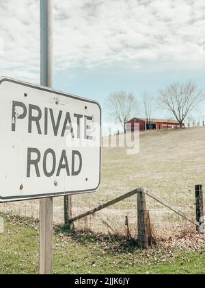 Un cliché vertical d'un panneau de route privé et d'un bâtiment éloigné Banque D'Images