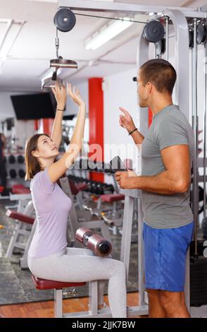 Femme faisant des exercices avec l'aide de l'entraîneur Banque D'Images