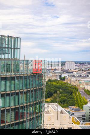 Berlin, Allemagne - 29 juin 2022: Le logo de la Deutsche Bahn sur le dessus de la tour de Bahntour, siège de la voie ferrée allemande. La ligne d'horizon de Berliner en arrière-plan Banque D'Images