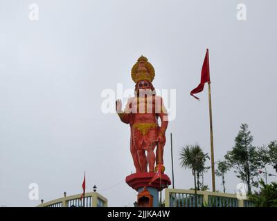 Une vue sur la statue de haunman hindou god dans le temple de Kalimpong Sikkim avec un drapeau et des arbres sur fond Banque D'Images