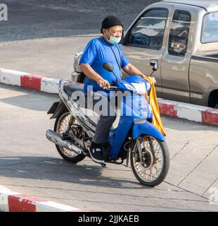 SAMUT PRAKAN, THAÏLANDE, APR 15 2022, Un homme avec masque de visage fait une moto sur la route Banque D'Images